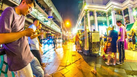 BANGKOK - FEBRUARY 21: Time-lapse view on a busy street close to the famous shrine Erawan as People pass by on February 21, 2018 in Bangkok, Thailand.
