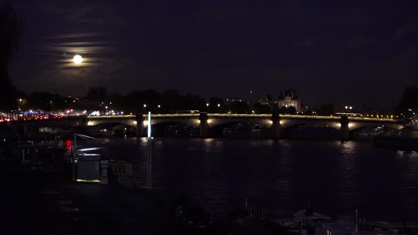 Ship and boats passing by Pont de la Concorde, night in Paris, France