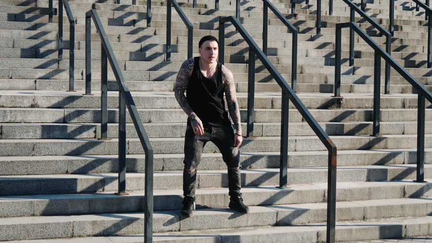 Contemporary hip hop street dancer hipster man with tattoo funky urban dancing freestyle in the city. 4k slow motion