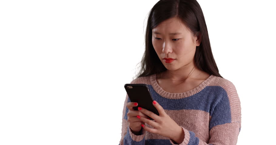 Lovely millennial woman using smart phone device to reply to text message on isolated white background. Close up of young Asian woman sending texts with cellphone on copyspace. 4k
