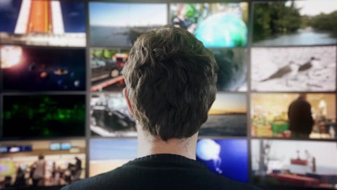 Wall Of Monitors. Head shot of a man watching many videos in a wall of televisions