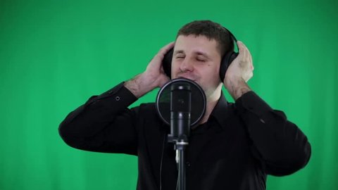 A man in the studio sings into the microphone.