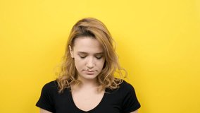 Young beautiful woman talking to the phone on yellow background in slow motion