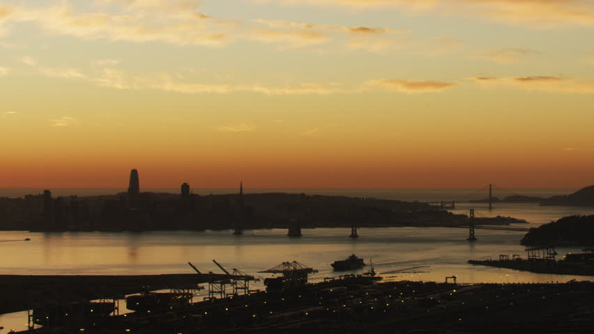 Aerial sunset view of San Francisco city Oakland bay bridge US 80 and Oakland Port docks California America