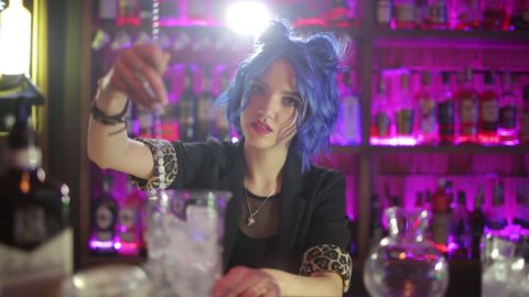 female bartender. girl with blue hair. cocktail making in night bar