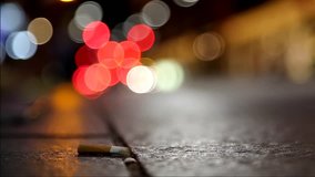 cigarette butts on the roadside. meaningful stock video. bokeh background.