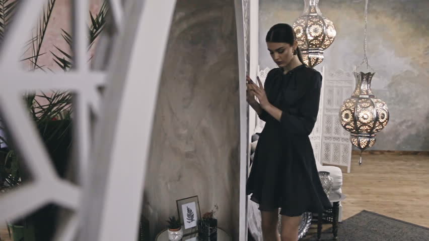 Beautiful sexy woman brunette hair east style arabic morocco furniture glamour model pose fashion clothes silk dress with bow accessory hand bag make up cosmetic pretty face party office room.