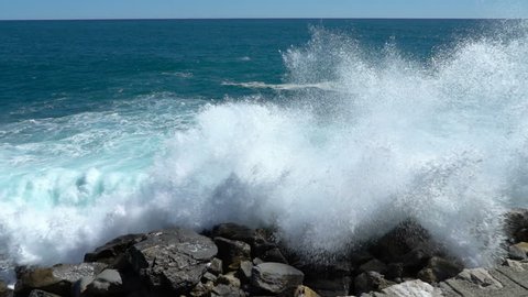 Huge waves break on the coastal cliffs of the Italian Riviera. Slow motion.