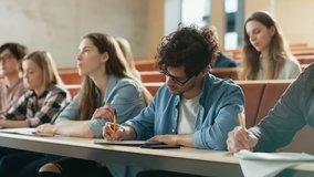 Hispanic Young Man Among His Fellow Students in the Classroom. Young Bright People Listening to a Lecture and Take Notes while Studying at the University.  - Powered by Shutterstock - Get 15% off with code: PIKWIZARD15