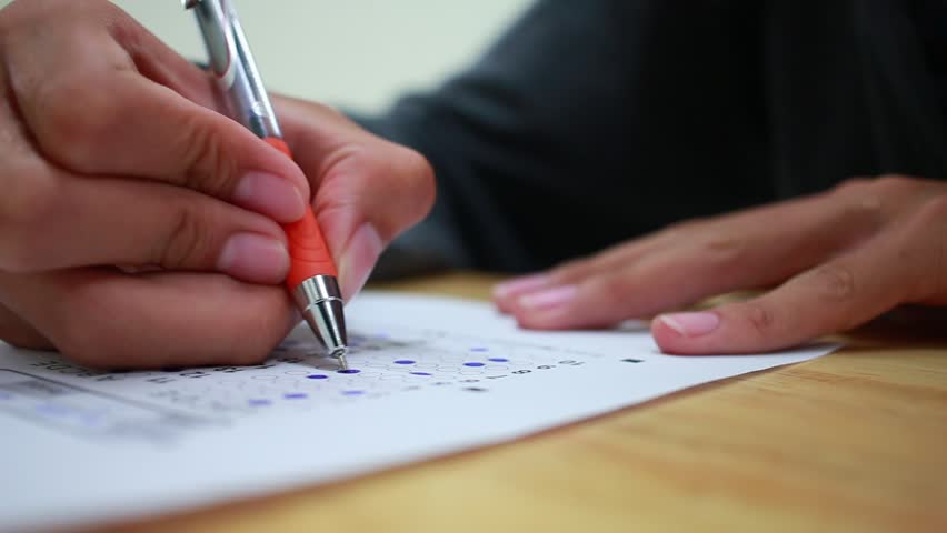 Students taking exams writing on optical form of standardized exam near Alarm clock with  holding yellow pen for final examination in secondary school, college university classroom, Education concept Royalty-Free Stock Footage #1009958099