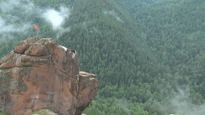 A man walks on a rope stretched at an altitude between two peaks in the Siberian nature reserve Stolby.