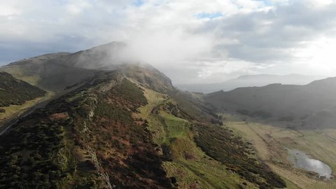 Aerial drone footage after rain at Arthur's seat with foggy and clouds, Edinburgh, Scotland, United Kingdom.