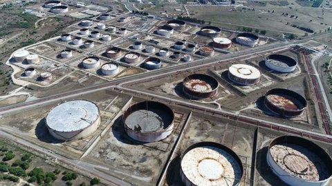 Aerial of empty oil depots sometimes called tank farm installation or oil terminal is an industrial facility for the storage of oil and other petrochemical products indicating low oil reserves 4k