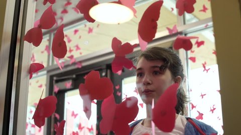 Teenagers decorating glass walls with butterfly cutouts