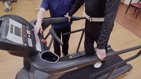 Medium shot of a senior man walking on a rehabilitation treadmill