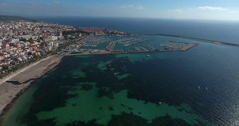 ALGHERO, SARDINIA, ITALY – JULY 2016 : Aerial shot over Alghero cityscape on a beautiful day with harbor and open sea in view