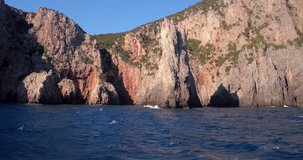 SARDINIA, ITALY – JULY 2016 : Video shot of cliffs on Porto Flava beach on a sunny day with cave, sea and blue sky in view