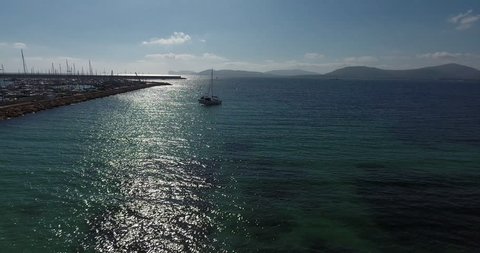 ALGHERO, SARDINIA, ITALY – JULY 2016 : Aerial shot over boat on a sunny day with Alghero harbor and sea in view
