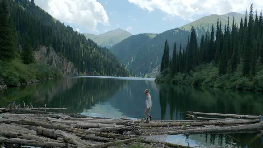 Woman hiking by lake in mountains of Kazakhstan