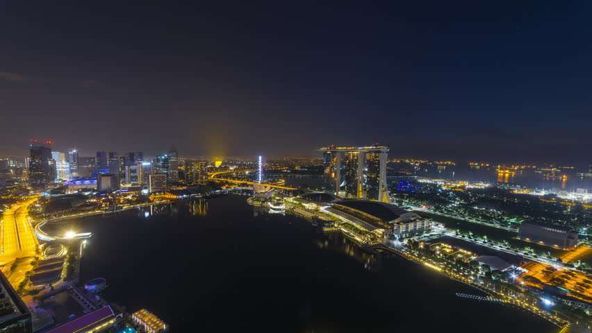 Time lapse: Aerial view of Singapore skyline overlooking the Marina Bay Quay during sunrise from night to day. 4K Prores. Royalty-Free Stock Footage #1009996502