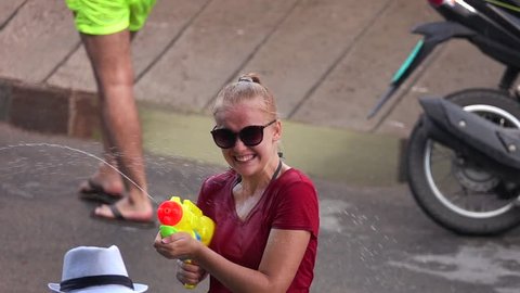 Young Female Caucasian Tourist Shooting Water Gun at Songkran Festival (Thai New Year)