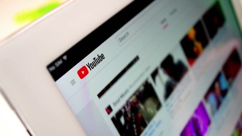 London / United Kingdom - april 17 2018: Youtube website on the tablet computer screen. User browse Youtube channel and trends video. Close up shot, 
 logo in the focus. 