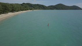 Drone view aerial view of young woman on stand up paddle on sea, tropical climate in Thailand, sport and recreation people concept. Shot in 4K resolution travel vacations enjoyment