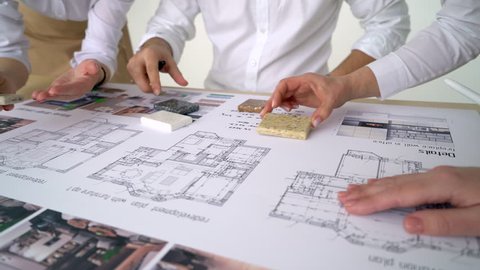 two Architects Discussing Plan Together At Desk With Blueprints. Close up of hands of an architects. designers architects team project working on desk close up. 4 k. hand pointing, blueprint decorator