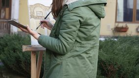 Young artists draw in the city . Artists painting picture on the street. Students paint building of the old European city