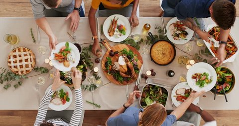 top view of young cheerful multi ethnic friends preparing table enjoying vibrant thanksgiving lunch together talking bonding over healthy meal time lapse