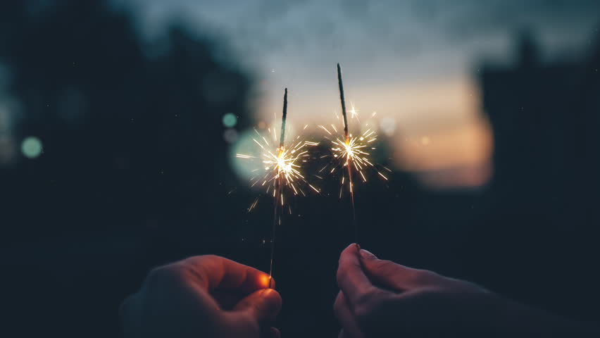 Cinemagraph 4K couple holding sparklers at the sunset in the rooftop watching the city lights. Royalty-Free Stock Footage #1010020853