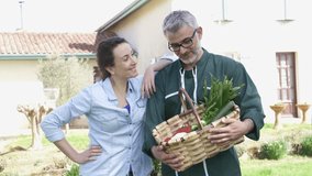 Happy couple of farmers holding vegetable basket