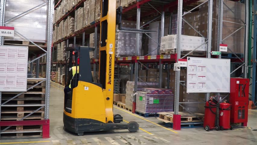 Moscow, Russia - May, 2017: Lift truck in factory. Clip. Wholesale logistic, loading, shipment and people concept - man with loader carrying cargo at warehouse | Shutterstock HD Video #1010032640