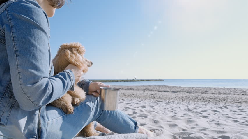 Woman with her dog at sandy sea beach. Conceptual freedom, travel and holidays image.