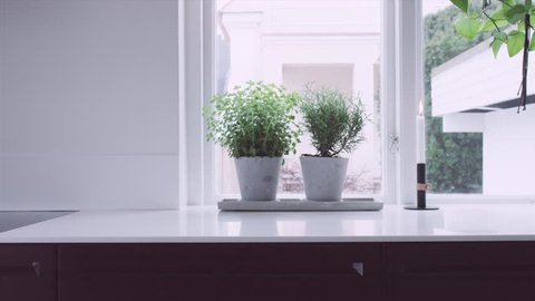 A tracking wide shot inside a modern Scandinavian house. Kitchen and dining area. Slow motion. UltraHD. ProRes444.