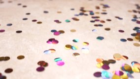 slow motion. 4k. round multicolored confetti lie on the tiled floor. dolly shooting