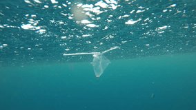 Plastic pollution in ocean environmental problem. Plastic bags, cups, straws and bottles discarded in sea
