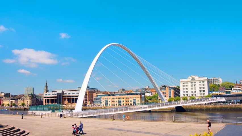 Newcastle upon Tyne, UK. Opening of Millennium bridge during the sunny day in Newcastle, UK. Time-lapse of people watching the bridge with historical buildings at the background