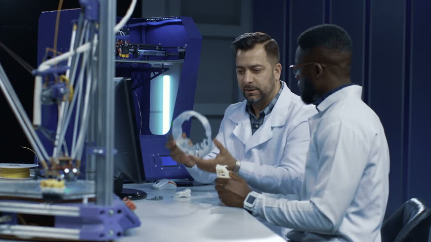 Side view of multiethnic researchers discussing possibilities of 3-D printing for prosthetic and medical engineering. | Shutterstock HD Video #1010067410