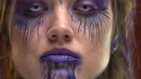 Makeup in purple tones on a crazy girl with pigtails, body painting