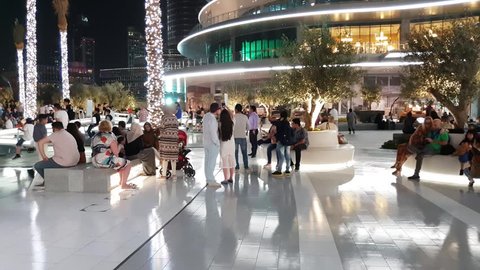 Dubai, UAE - April 8. 2018. Tourists on square at front of Dubai Mall.