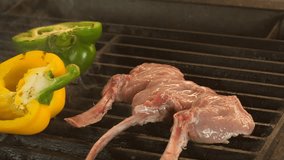 High quality video of grilled steaks in real slow motion, the process of cooking lamb or veal on bone and vegetables, three beautiful even pieces of steak on the bone are lined with scarcely grilled