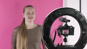 Teen girl vlogger recording vlog for her lifestyle channel at home studio. Happy young girl talking to camera. Using digital camera with external mic mounted on led ring light to record a video blog.