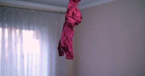 Bra hanging on a chandelier on the ceiling