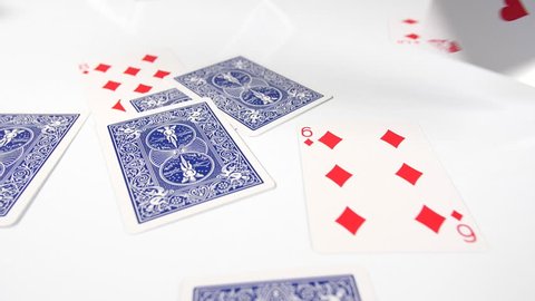 
slow motion falling deck of cards onto white surface. Casino or gabling playing cards floating down. Thrown magic trick. 