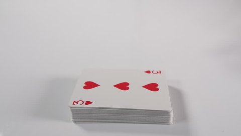slow motion of a Mans hand spreading a playing card deck on a white surface background. Magician or casino dealer playing with cards. Dolly tracking shot of hand. 