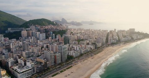 Aerial view of Rio de Janeiro flying towards Copacabana Beach with waterfront street, Brazil. Light effect applied.