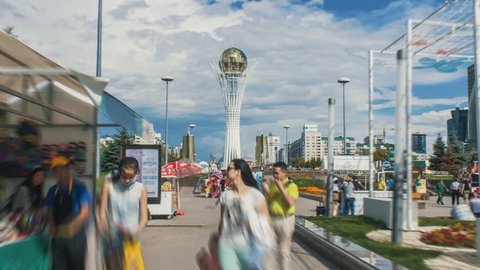 Kazakhstan, Astana, July 19, 2017. People walk through the Nurljole boulevard. Astana-Bayterek. Baiterek Tower.  Day time motion timelapse at the Astana, with a cloudy sky. 