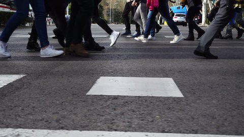 People cross the road on the crosswalk. Slow motion.