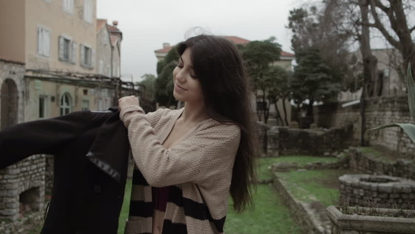 Beautiful young woman with black long hair walking around the city. Slow motion. Follow me
